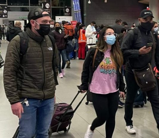 Viajeros usando tapabocas en el aeropuerto El Dorado de Bogotá